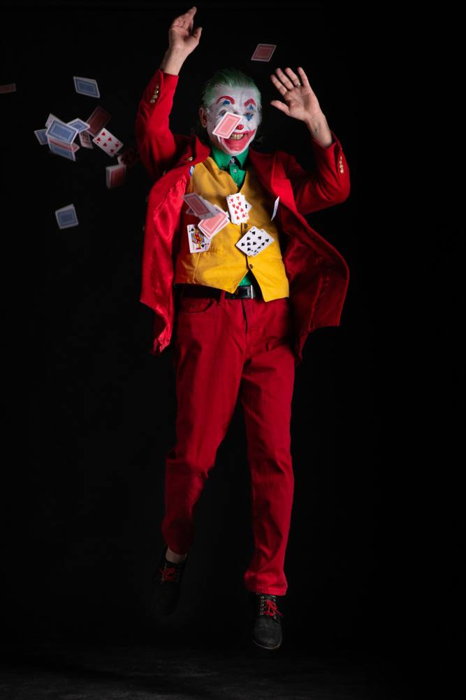 Joker che salta con le braccia alzate mentre le carte da gioco gli volano attorno